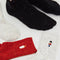 models wearing speckled crew socks: white socks with nutcracker, black socks with ornament and red socks with candle