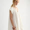 side view of model wearing cream cotton mini dress with crochet scalloped deep v-neckline and cap sleeves