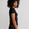 side view of model wearing black lace short sleeve top with leather pants