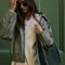 model carrying dark olive suede small handbag with piped handles