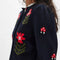 side view of model wearing black cropped cardigan with red folk floral print on the front and sleeves