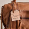 brown leather barrel purse with long strap zipper pulls and various zipper compartments
