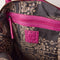 grey and tan printed interior of raspberry pink leather tote bag with several zipper pockets, double handles, and crossbody strap