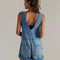 back view of model wearing light denim pull on shortalls with zipper front