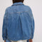 back view of model wearing light blue cropped denim jacket with front patch pockets