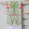 folded white tea towel with abstract pink poppy print and greenery