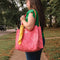 model carrying pink quilted floral tote bag with yellow printed interior
