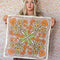 model holding cream background bandana with orange, green, gold and pink with chocolate brown outlines