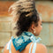 model wearing dark and medium blue, cream tiled square bandana around their neck