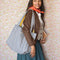 model carrying blue and white gingham tote bag with yellow printed interior