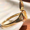 side view of opened gold ring with heart shaped locket