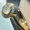 side view of gold band ring with opal stone surrounded by crystal stone border