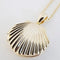up close of long gold seashell necklace