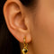 model wearing gold hoop earrings with detachable dainty heart charm