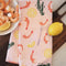 light pink cotton tea towel with shrimp cocktail and lemon print