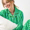 model wearing kelly green and sky blue vertical stripe pj set