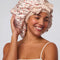 model wearing light pink cherry print adjustable oversized satin bonnet
