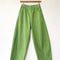 pistachio green arc pants with side pockets on a hanger