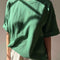 model wearing moss green oversized tee with extended sleeves