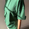 side view of model wearing moss green oversized tee with extended sleeves