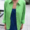 model wearing un-buttoned oversized spring green button down top