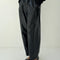 model wearing shiny black relaxed fit pants with side inlets