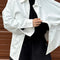 model wearing un-buttoned oversized cotton white button down top