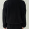 back view of model wearing black colored waffle sweatshirt with slight balloon sleeves