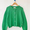spring green cotton cardigan on a hanger
