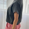side view of model wearing coal tee with slight cap sleeves, relaxed fit, and banded bottom