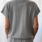 back view of model wearing heather grey tee with slight cap sleeves, relaxed fit, and banded bottom