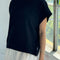 side view of model wearing black relaxed tee with muscle tee sleeves and side vents at the hem