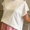 model wearing white relaxed tee with muscle tee sleeves and side vents at the hem