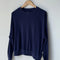 navy pointelle sweatshirt with banded bottom on a hanger