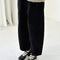 side view of model wearing black corduroy arc pants with side panels and pockets