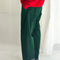 side view of model wearing dark green corduroy arc pants with side panels and pockets