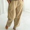 model wearing khaki corduroy arc pants with side panels and pockets
