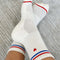 model wearing white socks with red and blue stripe with embroidered red heart