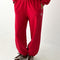 model wearing bright red french terry balloon pants with side pockets and side panels