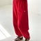 model wearing bright red french terry balloon pants with side pockets and side panels