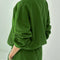 back view of model wearing avocado pull over sweatshirt with slight balloon sleeve and waist band
