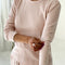 side view of model wearing light pink pointelle long sleeve tee