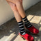 model wearing black high crew socks with white thin stripes
