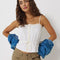 model wearing white cami tank with ruffle trim, button front and tie waist