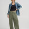model wearing olive green slouch chino pants with pleated front