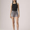 model wearing washed black shorts with frayed hem
