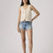 model wearing light denim low rise shorts with distressed hem