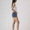 side view of model wearing dark denim low rise shorts with frayed hem
