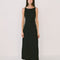 model wearing black crinkle maxi dress with asymmetrical hem and open back
