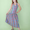 model wearing colorful plaid midi dress with button front, collar detail, and drop waist
